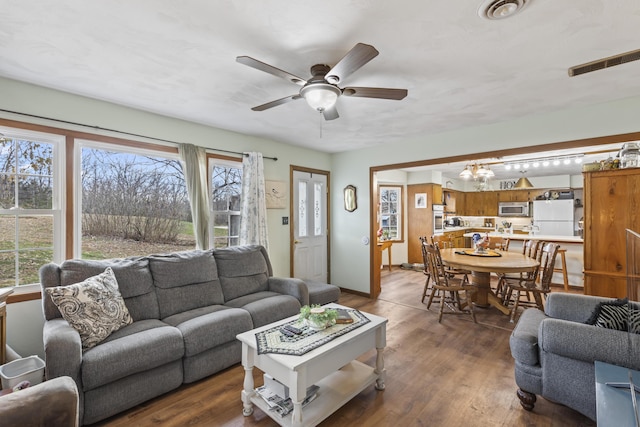 living room featuring ceiling fan and dark hardwood / wood-style flooring