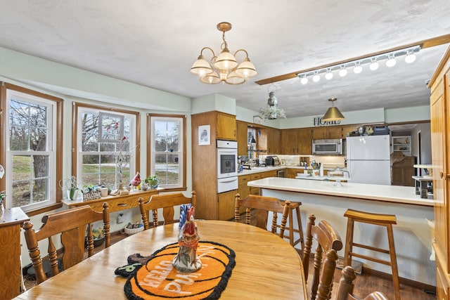 dining room featuring a notable chandelier and track lighting