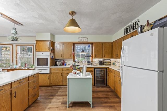 kitchen featuring wine cooler, dark wood-type flooring, white fridge, and a healthy amount of sunlight