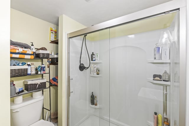 bathroom with toilet and an enclosed shower