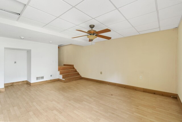 unfurnished room with a paneled ceiling, ceiling fan, and light hardwood / wood-style flooring