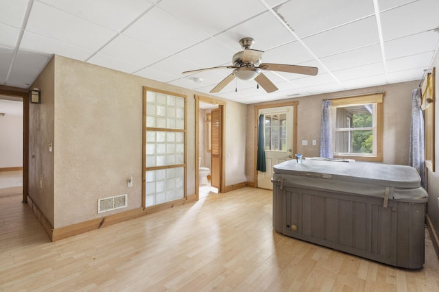 bathroom with ceiling fan, hardwood / wood-style floors, vanity, a drop ceiling, and toilet