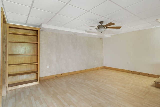 spare room featuring a drop ceiling, hardwood / wood-style floors, and ceiling fan