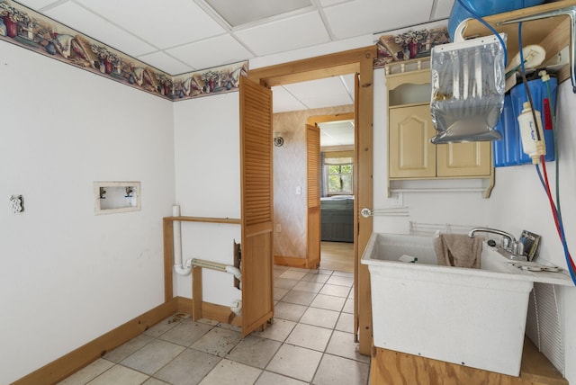 washroom featuring hookup for a washing machine, cabinets, sink, and light tile patterned floors