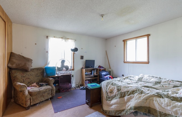 bedroom featuring light colored carpet and a textured ceiling