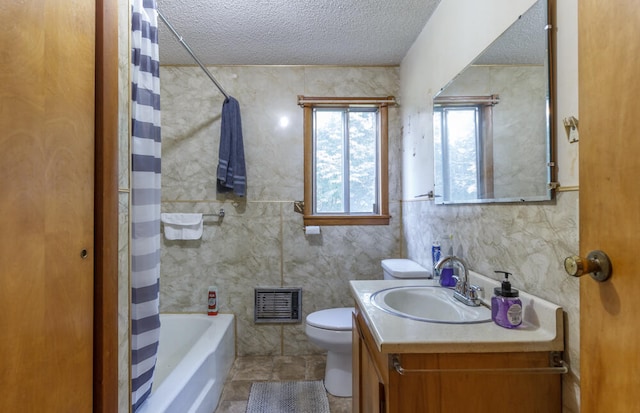 full bathroom featuring shower / tub combo, vanity, tile walls, toilet, and a textured ceiling