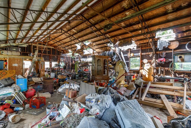 misc room featuring lofted ceiling, a workshop area, and concrete floors