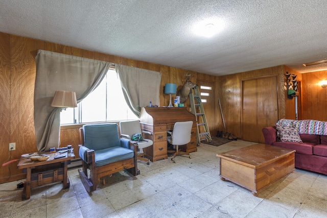 living room with wooden walls and a textured ceiling