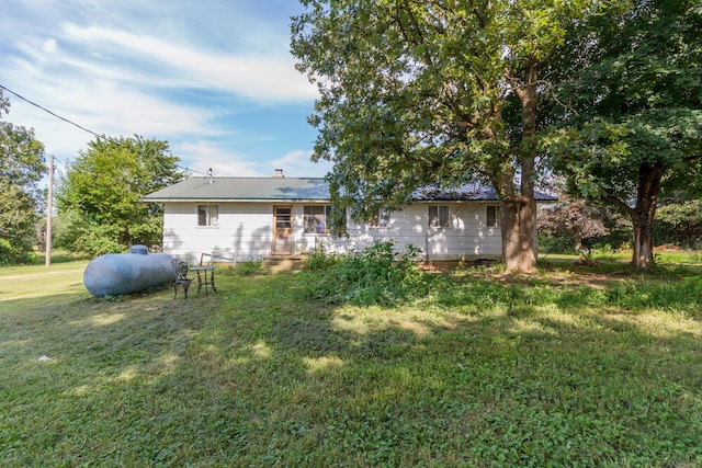 rear view of property featuring a lawn