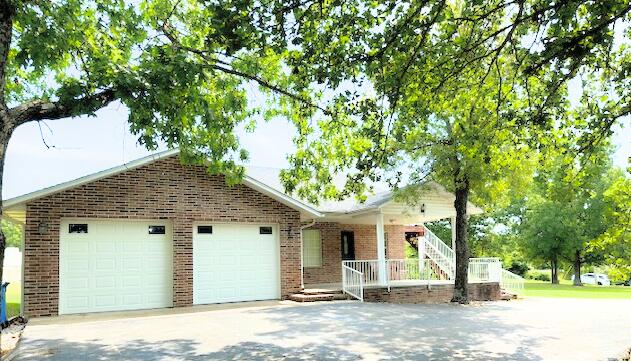 single story home with a garage and a porch