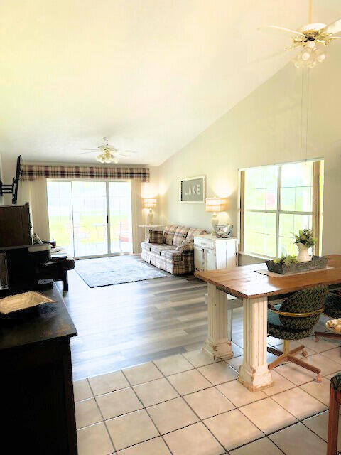 living room featuring light wood-type flooring, high vaulted ceiling, and ceiling fan