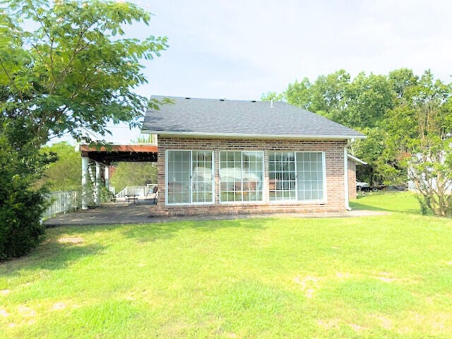 rear view of house with a yard and a patio