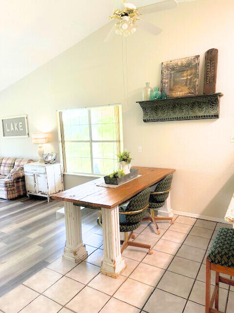 dining area featuring lofted ceiling, ceiling fan, and light hardwood / wood-style flooring