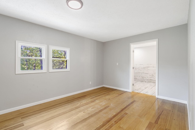 spare room featuring a textured ceiling and hardwood / wood-style flooring