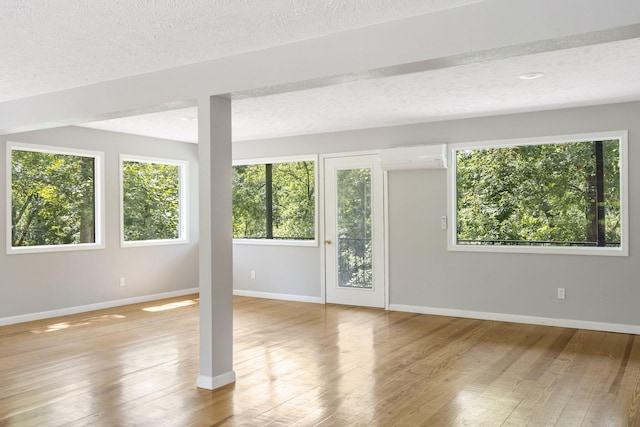 unfurnished room featuring a wall unit AC and light hardwood / wood-style floors