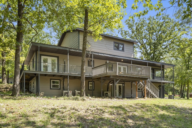 back of property with french doors, a deck, and a yard