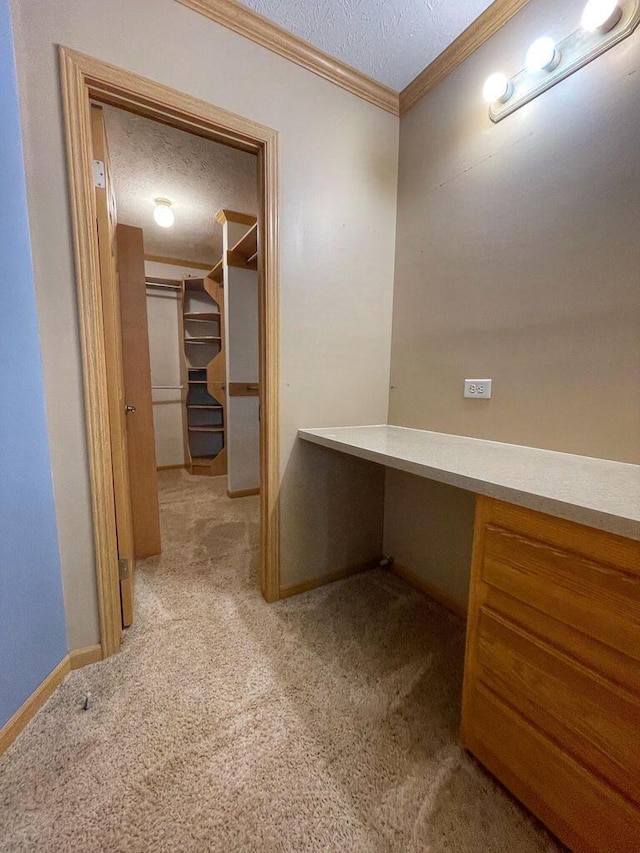 hall with baseboards, carpet flooring, a textured ceiling, and crown molding