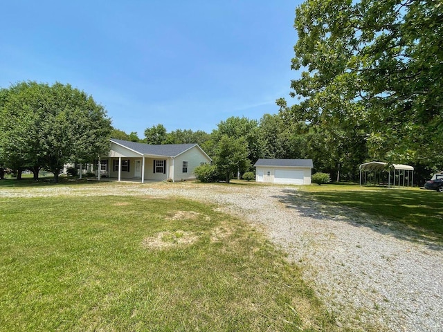 view of front of home with a front lawn, a detached garage, an outdoor structure, and covered porch