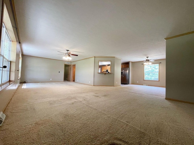 unfurnished living room with ceiling fan, a textured ceiling, and carpet flooring