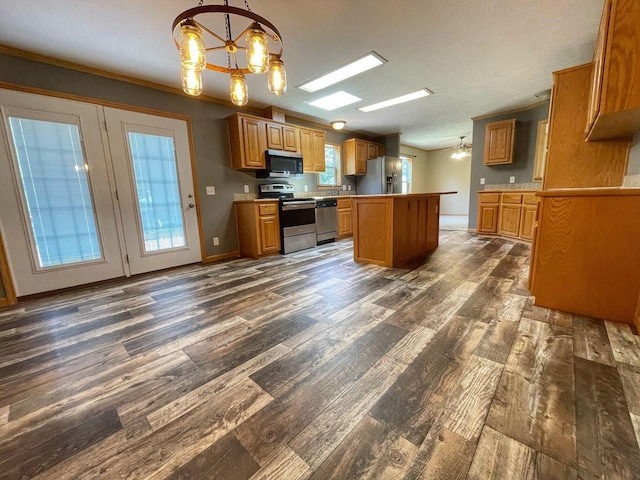 kitchen featuring dark hardwood / wood-style flooring, appliances with stainless steel finishes, an inviting chandelier, and a center island