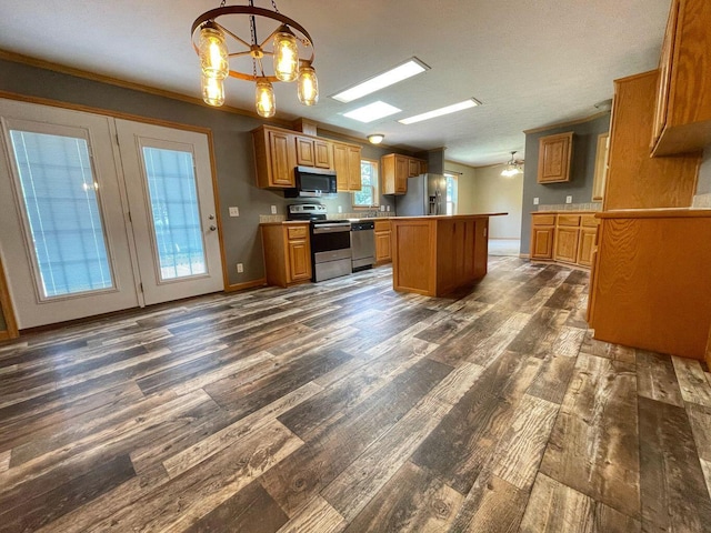 kitchen featuring dark wood finished floors, stainless steel appliances, an inviting chandelier, a center island, and brown cabinetry