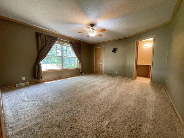 empty room with ceiling fan, light colored carpet, crown molding, and a textured ceiling