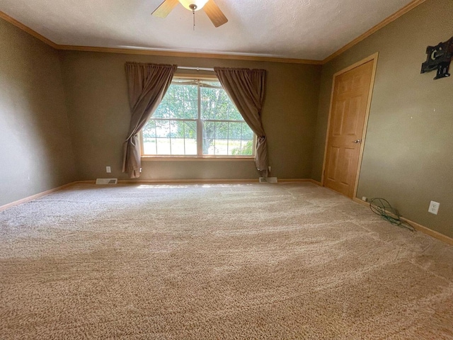 carpeted empty room with ornamental molding, a textured ceiling, and ceiling fan