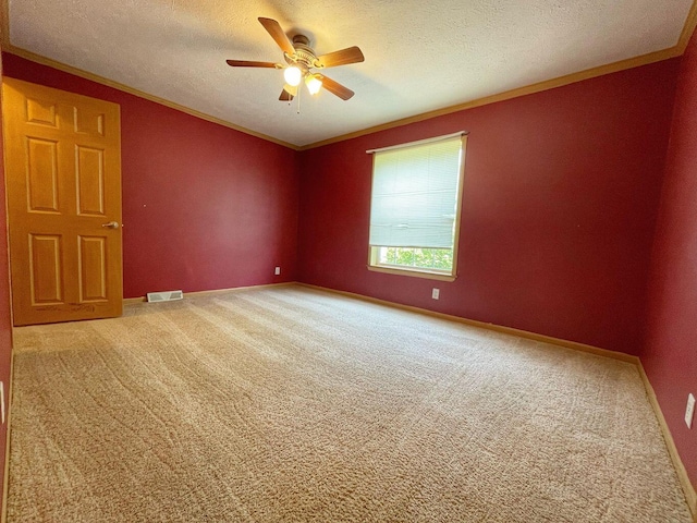 carpeted spare room with ornamental molding, a textured ceiling, and ceiling fan