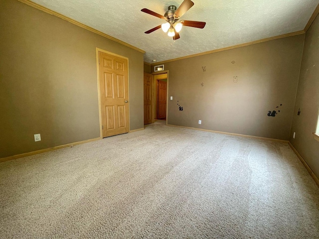 carpeted spare room with ornamental molding, ceiling fan, and a textured ceiling