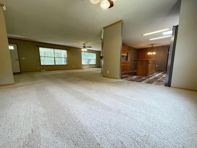 unfurnished living room with baseboards, light colored carpet, and ceiling fan