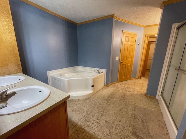 full bath featuring a textured ceiling, a sink, double vanity, a shower stall, and a garden tub