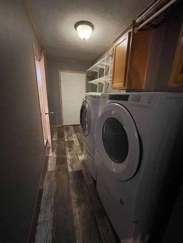 laundry area featuring cabinet space, dark wood finished floors, a textured ceiling, and washer and dryer