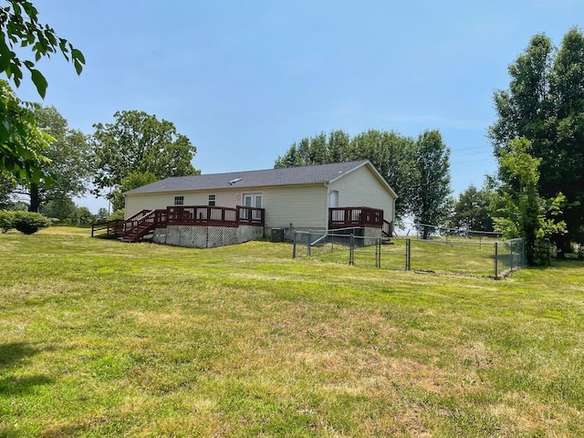 rear view of property featuring a yard and a wooden deck