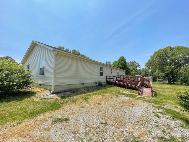 view of property exterior with a deck and a lawn