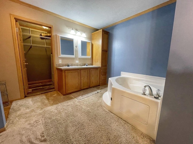 full bathroom featuring a garden tub, vanity, a walk in closet, crown molding, and a textured ceiling
