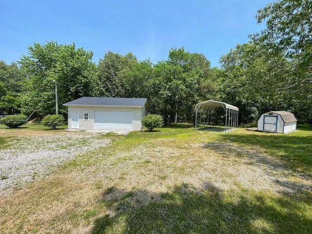 view of yard with an outbuilding, a carport, a storage unit, and a garage