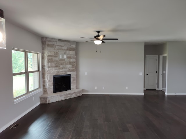 unfurnished living room with ceiling fan, a fireplace, and dark hardwood / wood-style floors