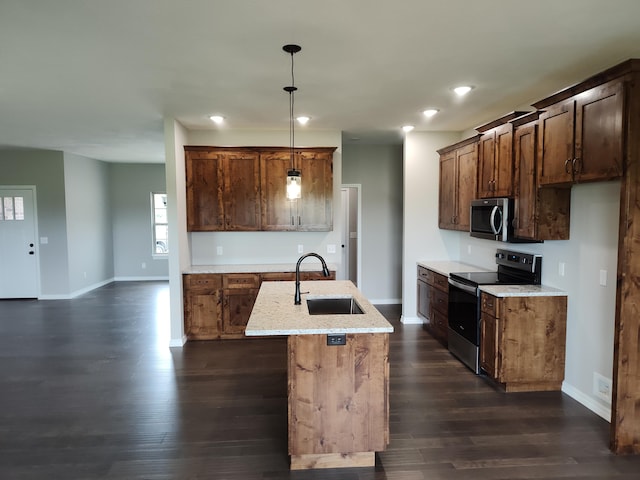 kitchen featuring sink, dark hardwood / wood-style floors, pendant lighting, a kitchen island with sink, and appliances with stainless steel finishes