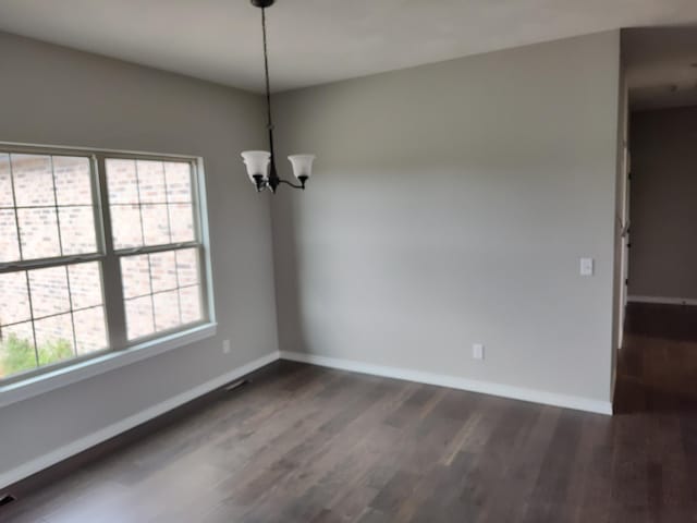 unfurnished dining area with a wealth of natural light, a chandelier, and dark hardwood / wood-style floors