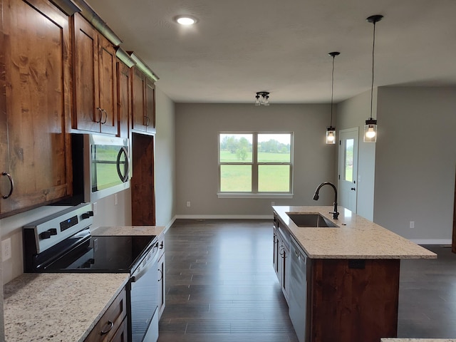 kitchen with sink, stainless steel appliances, light stone counters, dark hardwood / wood-style flooring, and an island with sink