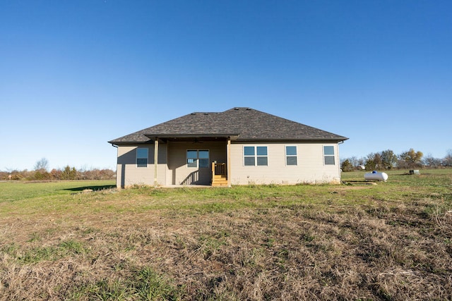 rear view of house featuring a yard