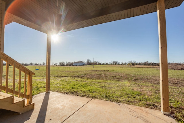 view of yard featuring a rural view and a patio