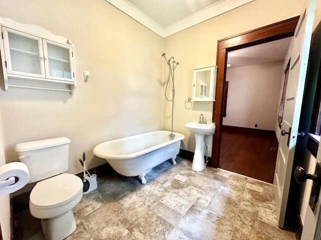 full bath with crown molding, a freestanding tub, baseboards, stone finish flooring, and toilet