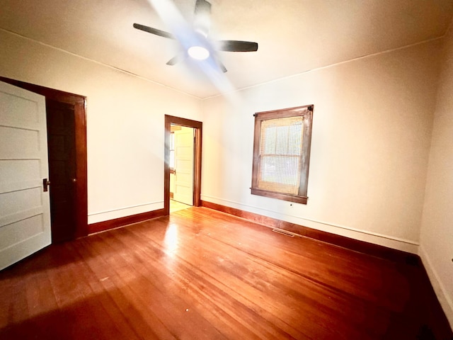 spare room with ceiling fan, baseboards, wood finished floors, and visible vents