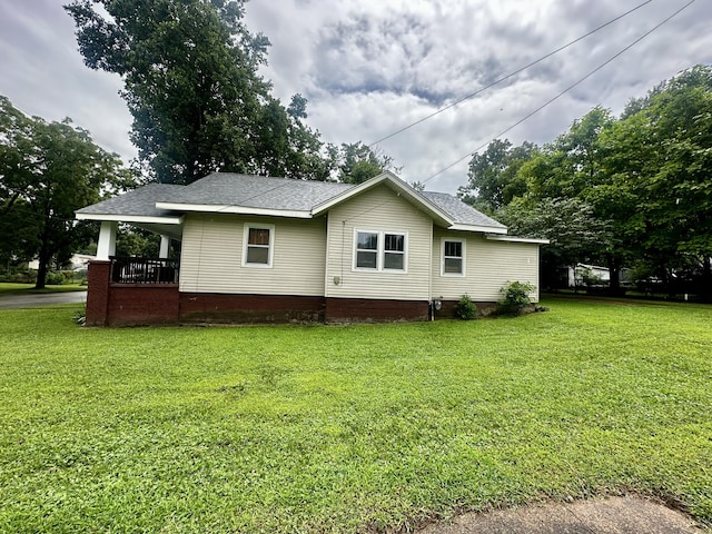 exterior space with a lawn and roof with shingles