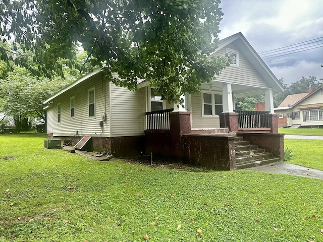 view of front of home featuring central AC, a front yard, and covered porch