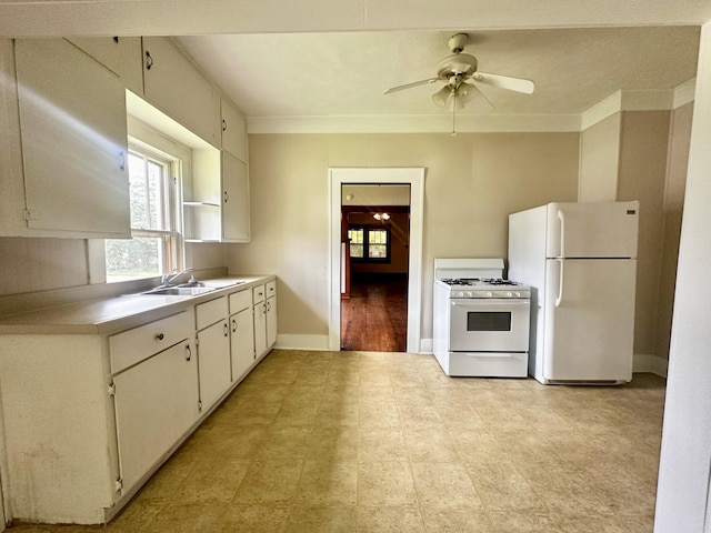 kitchen with white cabinets, light countertops, white appliances, baseboards, and ceiling fan