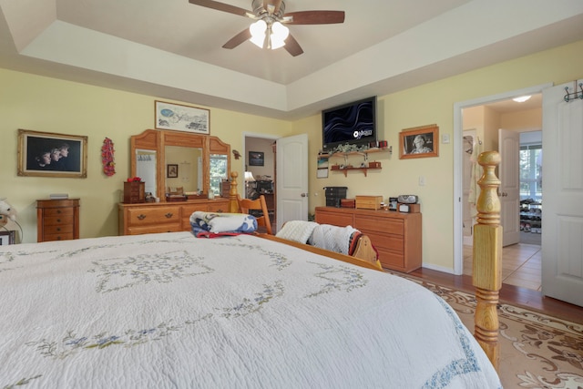 bedroom featuring a tray ceiling, ceiling fan, and hardwood / wood-style flooring