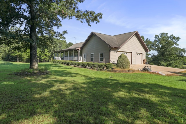 view of side of property with a porch, a garage, and a yard