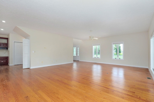 unfurnished room with ceiling fan, light hardwood / wood-style flooring, and a textured ceiling